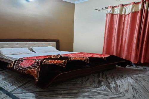 a bedroom with a bed with a red curtain at Hotel O Ocean's 11 in Daurāla