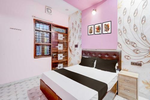 a bedroom with a bed in a room with pink walls at Hotel O Ocean's 11 in Daurāla