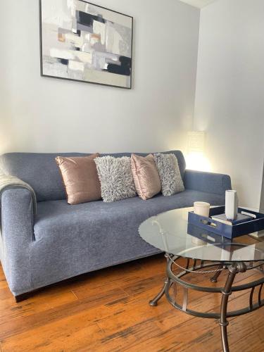 Una sala de estar con un sofá azul y una mesa de cristal. en Very comfortable 2 bdrm Condo in French Quarters, en Nueva Orleans