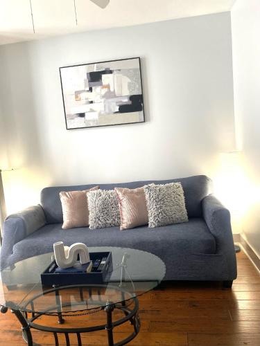Una sala de estar con un sofá azul y una mesa de cristal. en Very comfortable 2 bdrm Condo in French Quarters, en Nueva Orleans