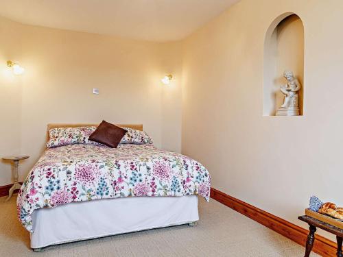 a bedroom with a bed and a statue on the wall at 2 Bed in Mattishall 57133 in Mattishall