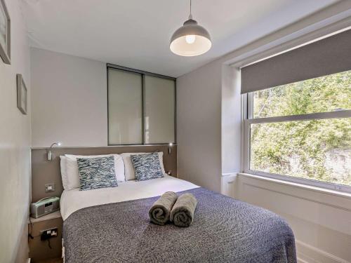 a bedroom with a bed with two slippers on it at 2 Bed in Aberdovey DY044 in Aberdyfi