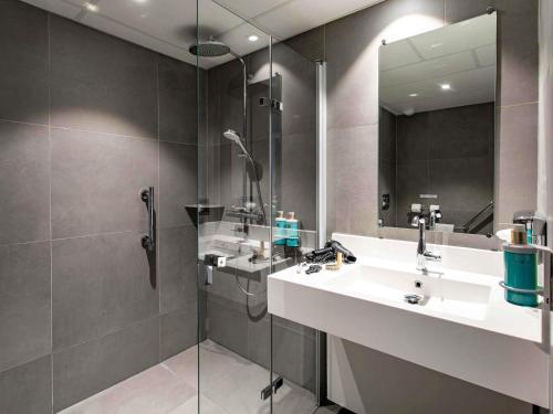 a bathroom with a sink and a shower at Novotel Beaune in Beaune