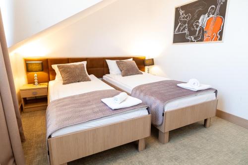 two beds in a small room with sidx sidx sidx sidx sidx at Hotel Avangarda in Różan