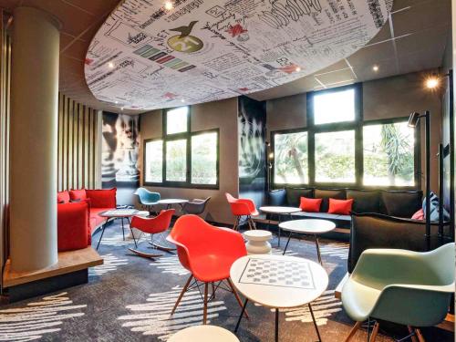a waiting room with colorful chairs and tables at ibis Hyeres Centre in Hyères