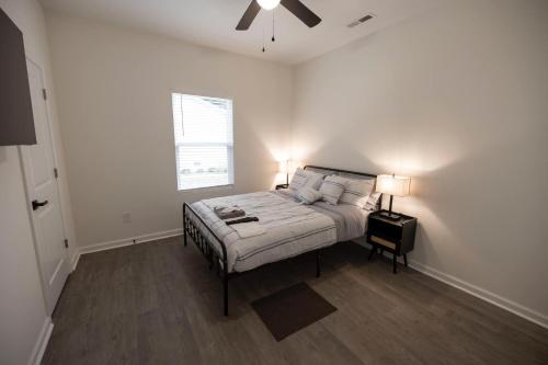 a white bedroom with a bed and a window at 4 Min to Downtown - 10 Min to Elon - Washer and Dryer in Burlington