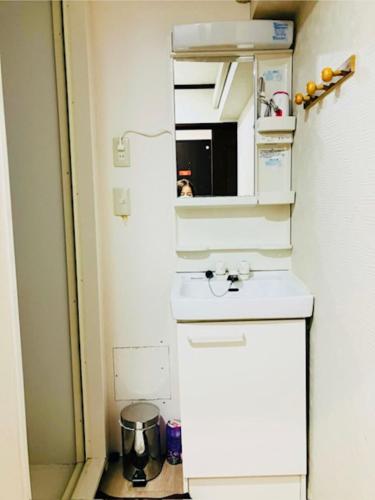 a small kitchen with a sink and a mirror at 冠京ホテル in Tokyo