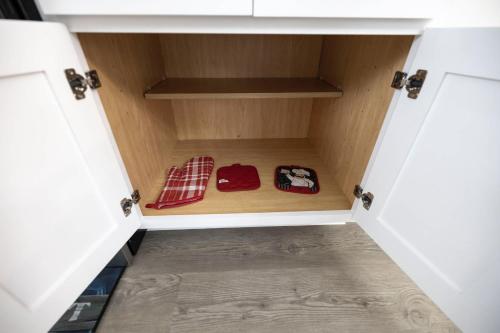 a cupboard with two mitts inside of it at 4 Min to Downtown - 10 Min to Elon - Washer and Dryer in Burlington