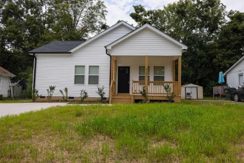 a white house with a porch and a yard at 4 Min to Downtown - 10 Min to Elon - Washer and Dryer in Burlington