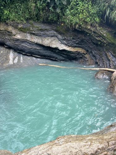 a pool of blue green water in a river at Refugio verde, interior 2 in Acacías
