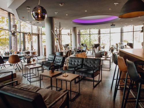 a room with chairs and tables and windows at Mercure Hotel Hamburg City in Hamburg