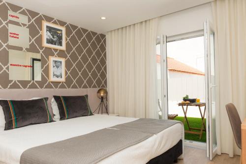 a bedroom with a large bed and a balcony at Sport Hotel A Seleção in Setúbal