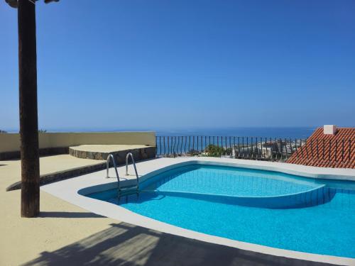Ein Swimmingpool mit dem Meer im Hintergrund in der Unterkunft Villa piscina privada MadreselvaSuite in San Bartolomé de Tirajana