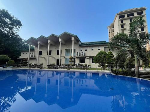 a large building with a blue pool in front of it at Seethawaka Regency in Avissawella