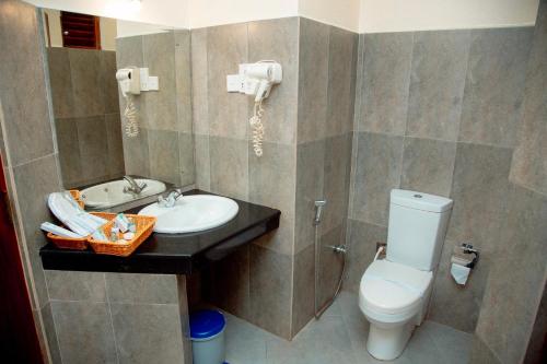 a bathroom with a white toilet and a sink at Seethawaka Regency in Avissawella