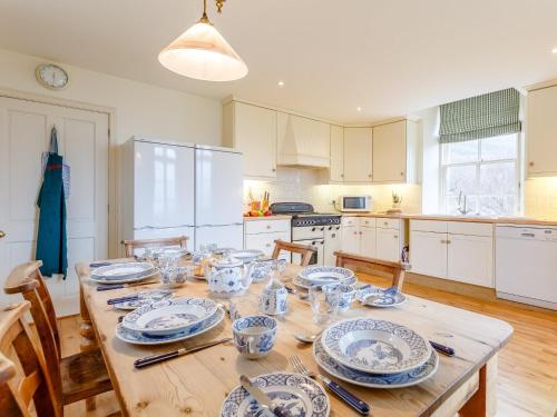a kitchen with a wooden table with dishes on it at 3 bed in Achnasheen CA120 in Inveralligin