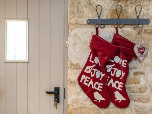 two red christmas mittens hanging on a wall at 1 Bed in Blockley 53420 in Blockley