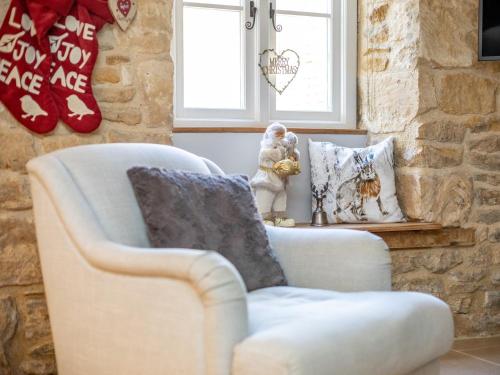 a living room with a chair and pillows at 1 Bed in Blockley 53420 in Blockley