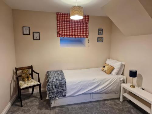 a small bedroom with a bed and a chair at The Old Nant-y-Fflint Chapel in Holywell
