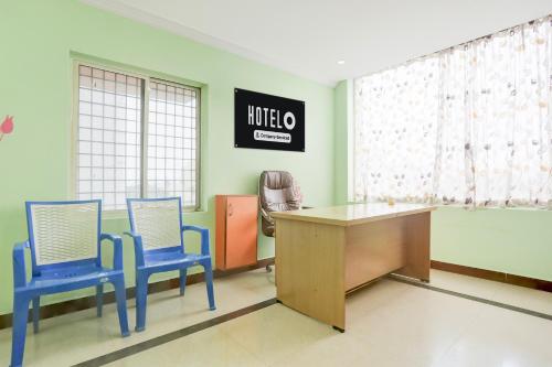 a hospital room with two blue chairs and a desk at Super Collection O Tirupati Central Junction Formerly Hotel Adith Grand in Tirupati