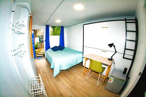 a small bedroom with a bed and a desk in a room at Alojamiento Ñuñoa Estadio Nacional in Santiago