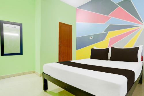 a bedroom with a bed with a colorful wall at Super Collection O Tirupati Central Junction Formerly Hotel Adith Grand in Tirupati