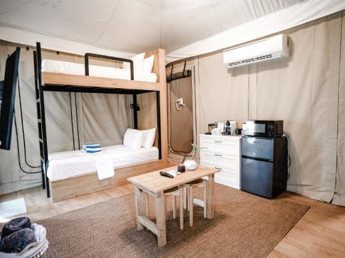 a room with a bunk bed with a table and a refrigerator at LasCalas Resort and Luxury Estate in Dasol