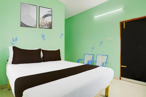 a bedroom with a bed and blue walls at Super Collection O Tirupati Central Junction Formerly Hotel Adith Grand in Tirupati