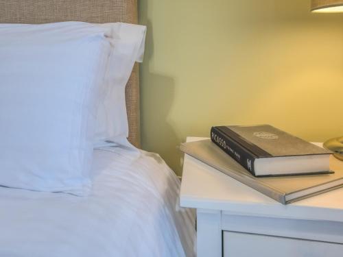 a book on a night stand next to a bed at 3 Bed in Tideswell 77955 in Tideswell