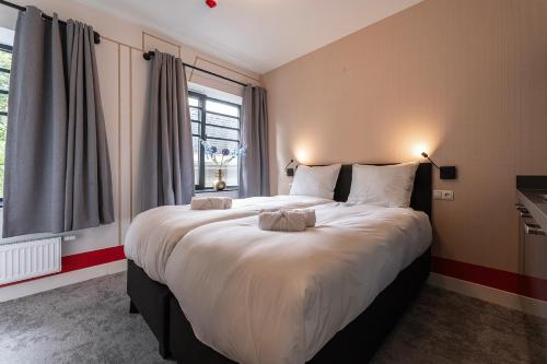 a large bed in a room with a large window at Central Tilburg Apartments in Tilburg