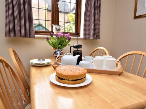 a wooden table with a cake on top of it at 2 Bed in Moreton-In-Marsh 75870 in Whichford