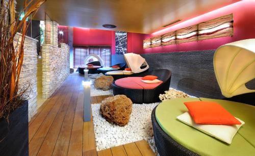 a living room with colorful furniture and a fireplace at Stammhaus im Hotel Alpine Palace in Saalbach Hinterglemm
