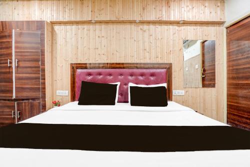 a bedroom with a large bed with a purple headboard at Super Collection O Tajganj West Gate Formerly Hotel Host in Tājganj