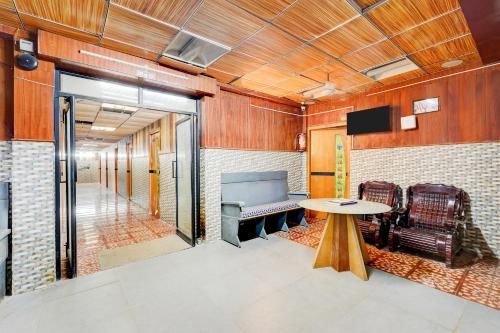 a room with a table and chairs and a tv at Hotel O Neyveli Central Railway Junction Formerly MP Residency in Neyveli