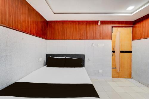 a bedroom with a bed and a wooden wall at Hotel O Neyveli Central Railway Junction Formerly MP Residency in Neyveli
