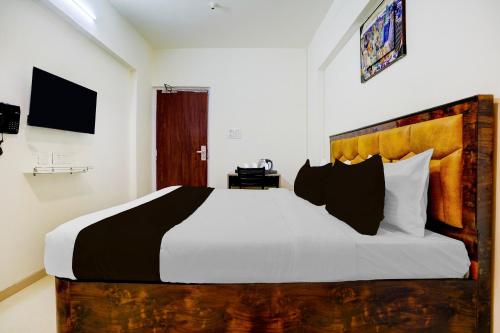 a bedroom with a large bed with black and white pillows at Townhouse Vangani Railway Station Formerly Hotel Chadha in Neral