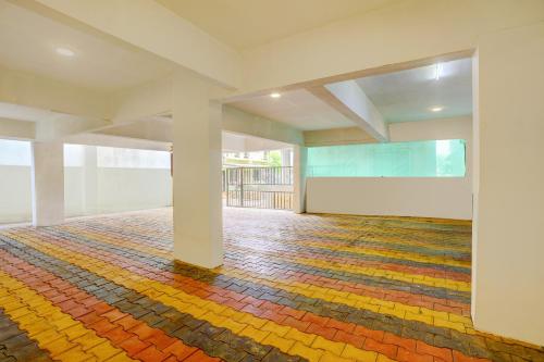 a large empty room with a colorful floor at Townhouse Vangani Railway Station Formerly Hotel Chadha in Neral