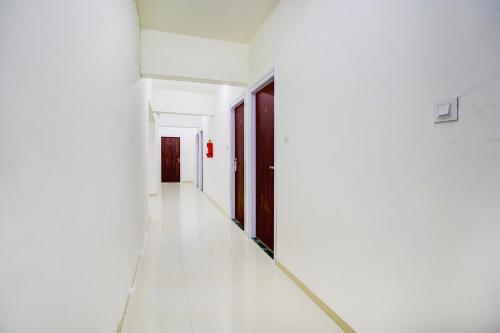an empty corridor of a white room with a hallway at Townhouse Vangani Railway Station Formerly Hotel Chadha in Neral
