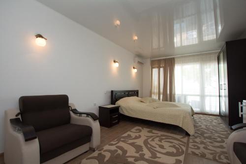 a bedroom with a bed and a chair at Kosmos 519 in Zatoka