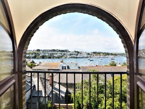 an arched window with a view of the water at 2 Bed in Polruan 75740 in Polruan