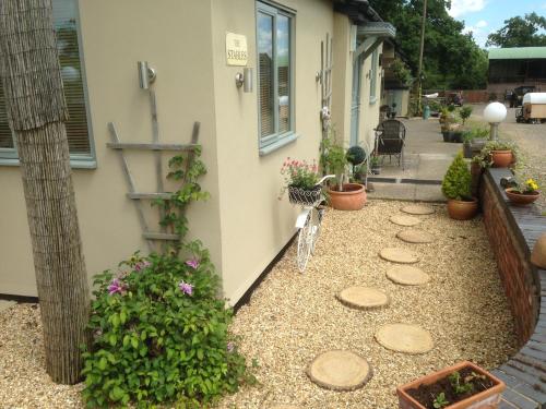 a garden with a bike parked next to a house at The Stables - Deer Park Farm in Solihull