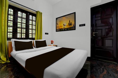 a large bed in a room with a door at Hotel O Kazhakuttam Railway Station Formerly Graceful Stay in Trivandrum