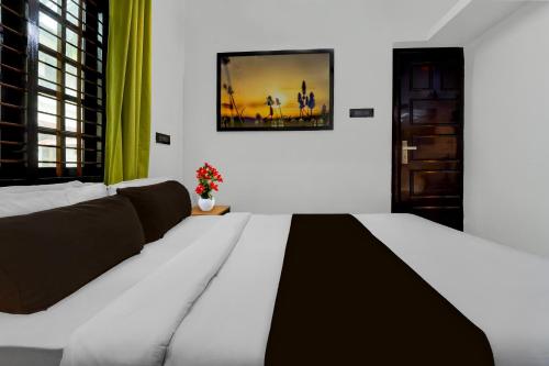 a bedroom with a large bed with a black and white blanket at Hotel O Kazhakuttam Railway Station Formerly Graceful Stay in Trivandrum