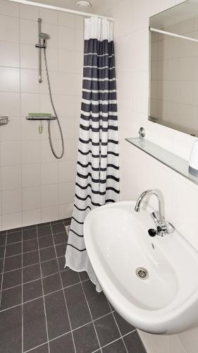 a white bathroom with a sink and a shower at Tussen de Diepen in Blokzijl