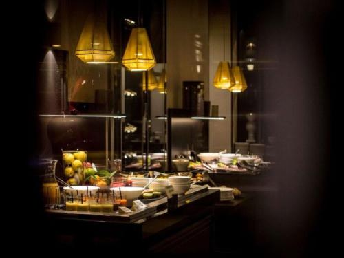 ディジョンにあるGrand Hôtel La Cloche Dijon - MGallery Collectionのビュッフェ形式の料理と照明を備えたキッチン