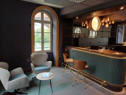 a waiting room with chairs and a counter and a table at Mercure Albi Rives du Tarn in Albi