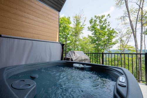 a hot tub on a balcony with a fence at Absolute comfort with spa - Le Panorama in Saint Come