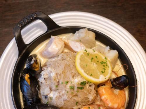a pan of food with a lemon on a plate at ibis Styles Le Puy en Velay in Le Puy en Velay
