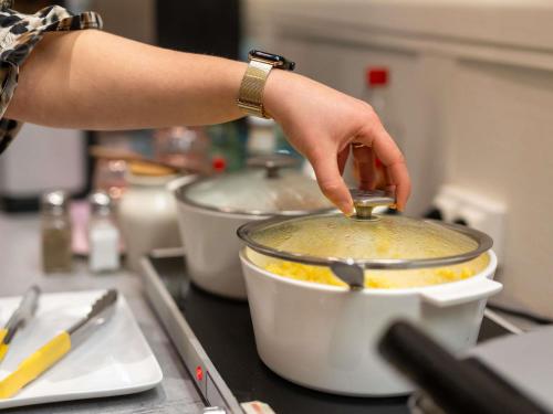 a person is stirring a pot with a spoon at ibis Styles Le Puy en Velay in Le Puy en Velay