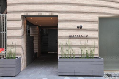 a building with two planters with plants in it at HOTEL AMANEK Ginza East in Tokyo